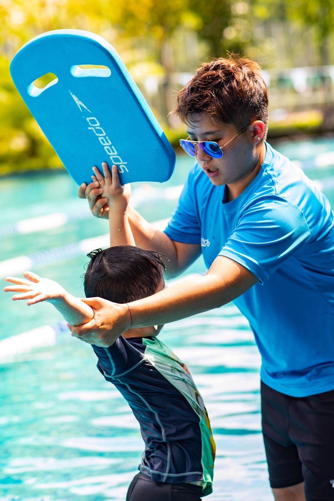 Coach supporting a child learning to float