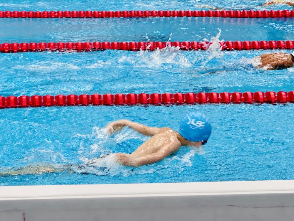 Swimmer racing freestyle at a meet