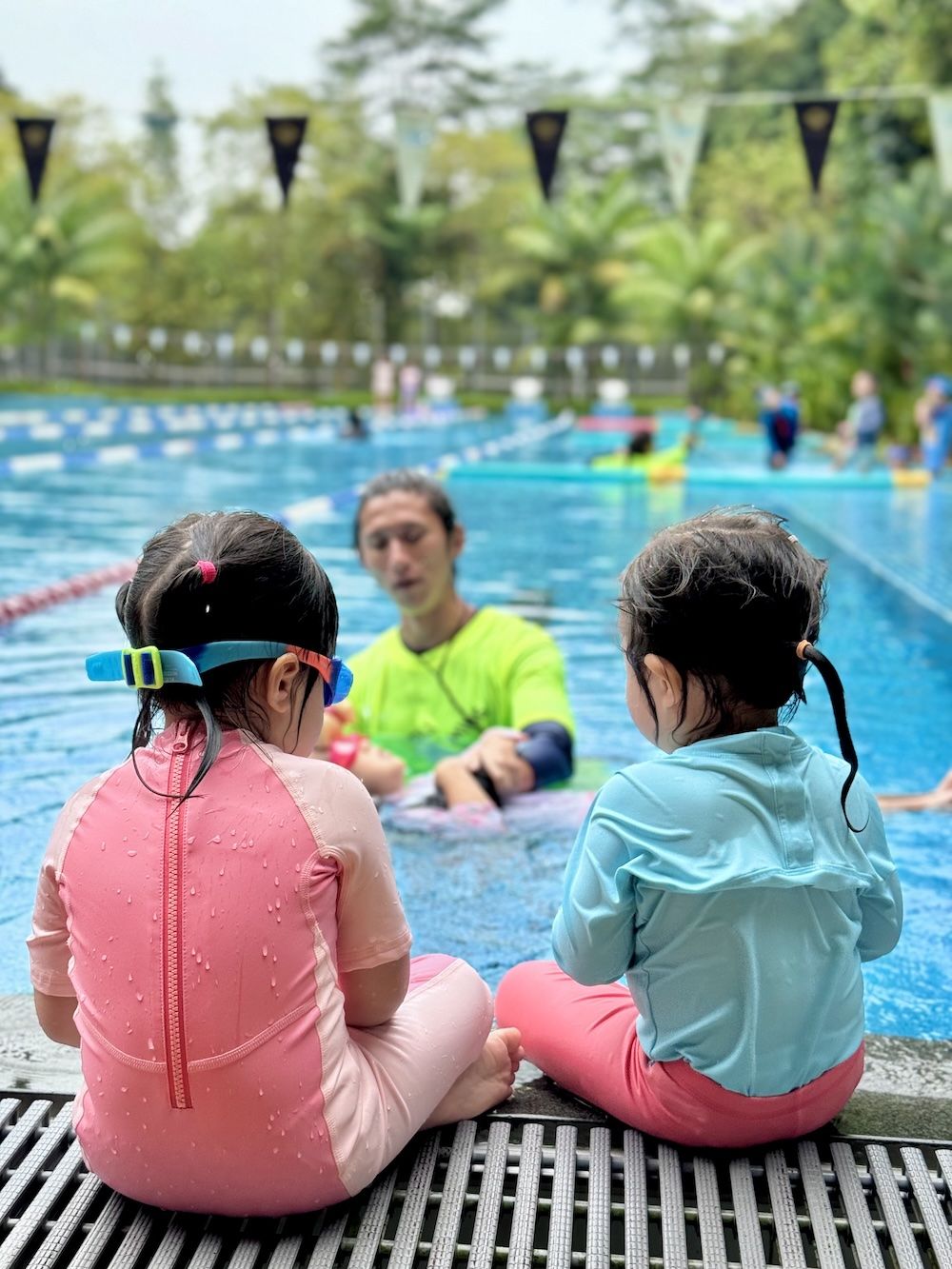 Coach teaching young children in the pool